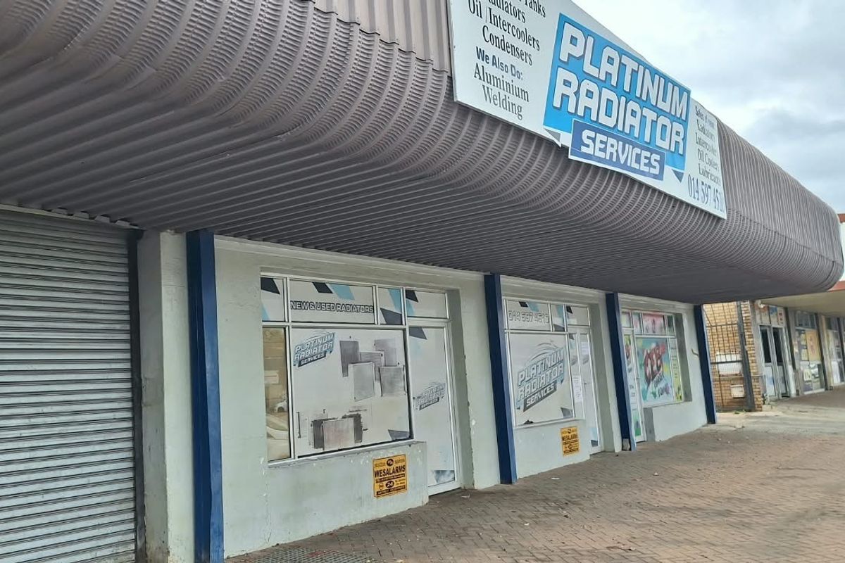 Commercial storefront featuring a large metal awning, roller shutter security, and prominent signage for a radiator service business.