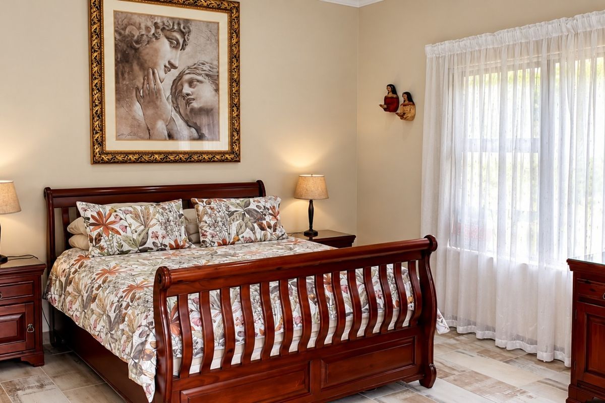 A well-maintained bedroom featuring tiled flooring and large windows with sheer curtains, providing a bright and comfortable living space.