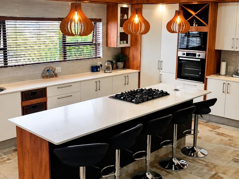 Modern kitchen featuring a central island with gas cooktop, built-in oven, ample cabinetry, and high-quality finishes throughout.