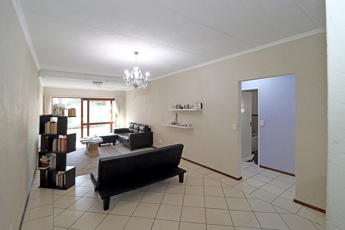 Spacious living room featuring tiled flooring, a coved ceiling, and a sliding glass door providing access to the exterior.