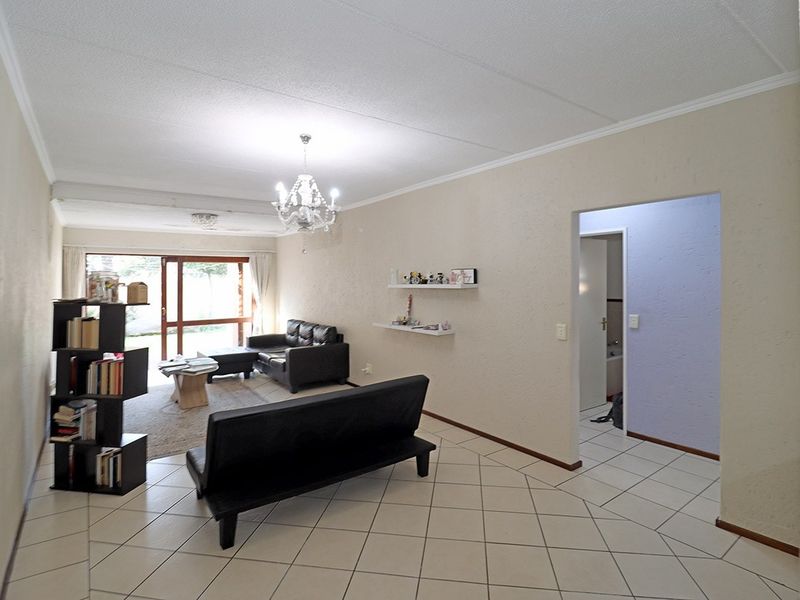 Spacious living room featuring tiled flooring, a coved ceiling, and a sliding glass door providing access to the exterior.
