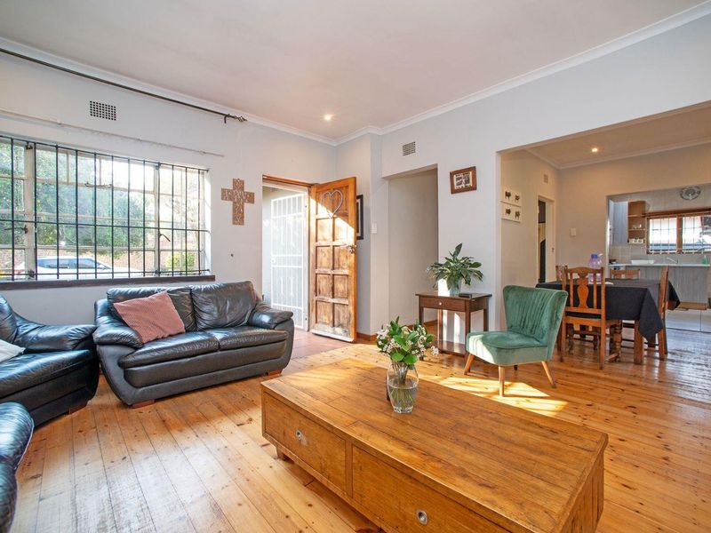 Open plan living and dining area featuring polished timber flooring, recessed lighting, and direct access to the front entrance.