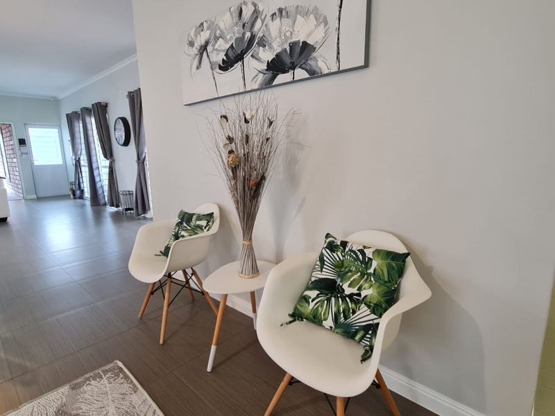 A bright and well-maintained living area featuring neutral wall tones, tiled flooring, and clean architectural finishes throughout the open-plan space.