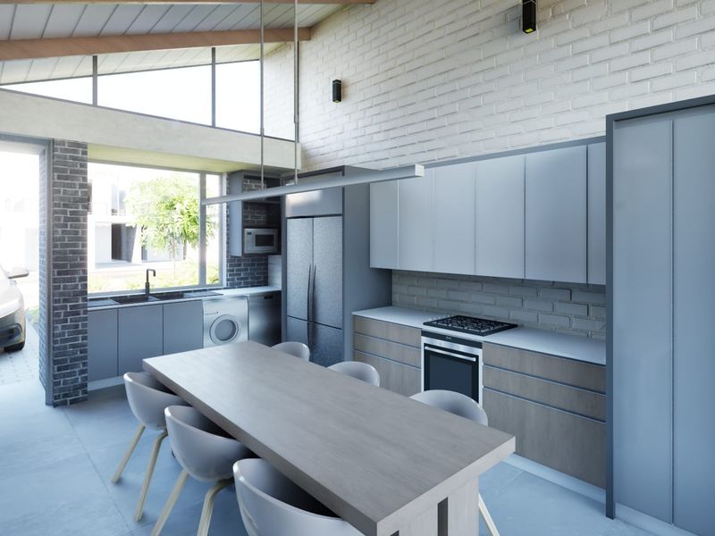 Modern open-plan kitchen and dining area featuring sleek cabinetry, built-in appliances, exposed brick walls, and high vaulted ceilings with clerestory windows.