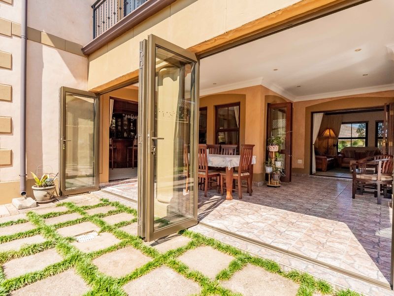 A covered patio area featuring tiled flooring and bi-fold glass doors that provide seamless indoor-outdoor flow to the garden.