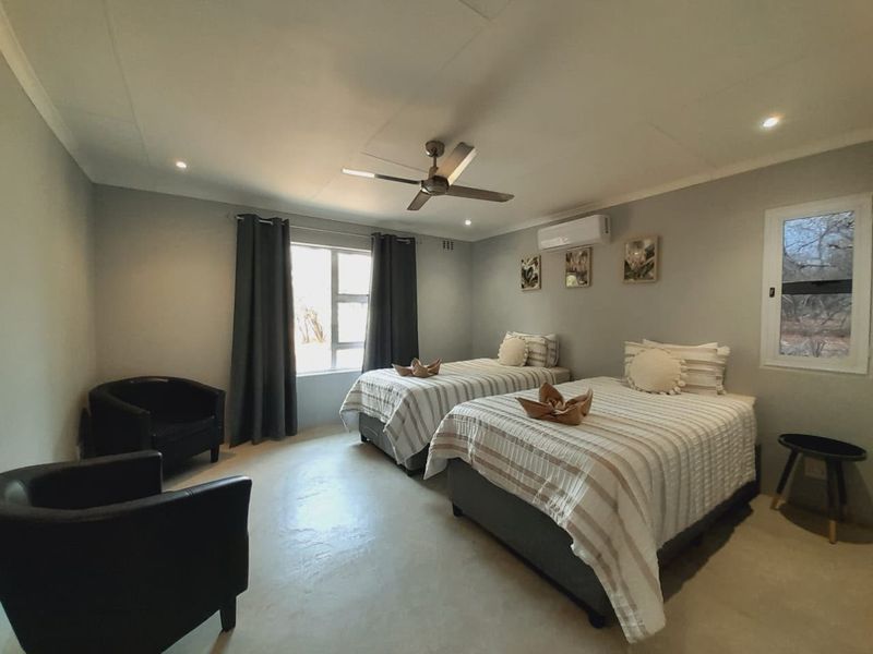 A well-maintained bedroom featuring a ceiling fan, split-system air conditioning, and recessed lighting, offering a comfortable and functional space.