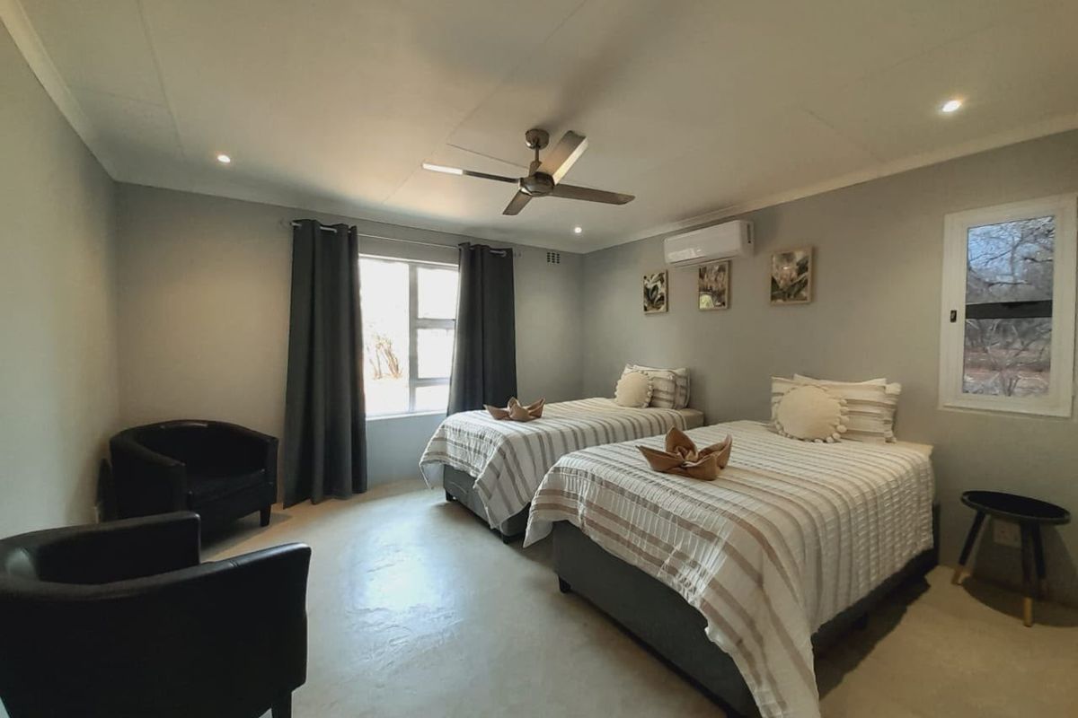 A well-maintained bedroom featuring a ceiling fan, split-system air conditioning, and recessed lighting, offering a comfortable and functional space.