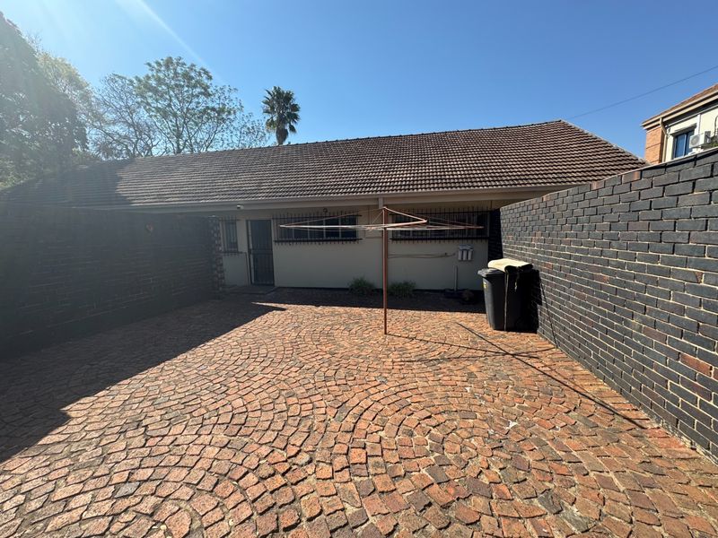 A private rear courtyard featuring brick paving, enclosed by high perimeter brick walls, providing a secure and low-maintenance outdoor space.