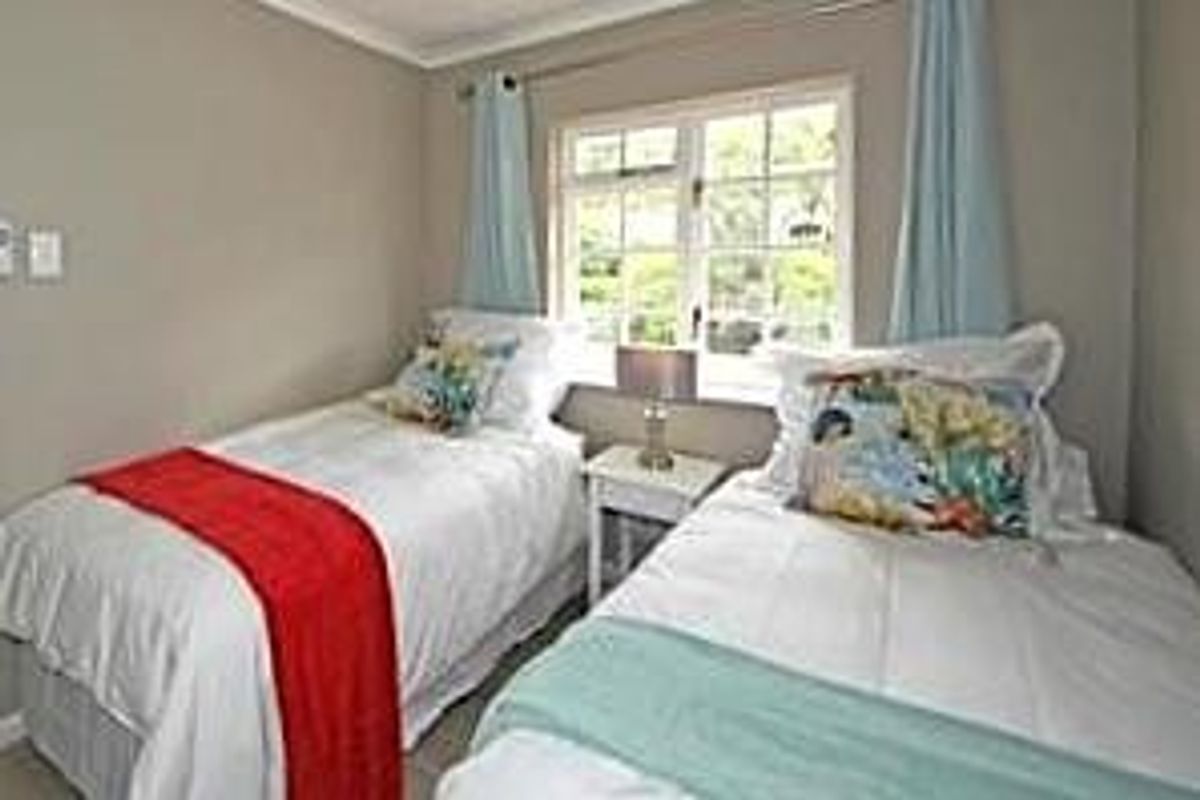 A compact bedroom featuring neutral wall tones and a window that provides natural light.