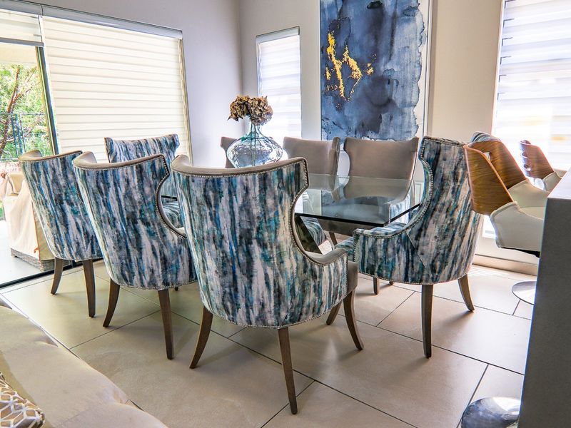 A bright dining area featuring large format floor tiles and sliding glass doors that provide seamless access to the outdoor patio space.