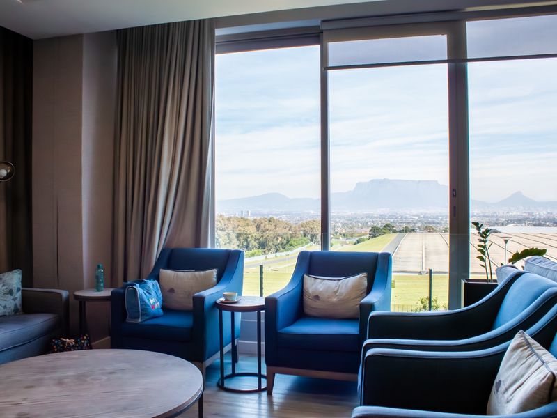 A comfortable living area featuring floor-to-ceiling windows that offer expansive views of the surrounding landscape and mountains.