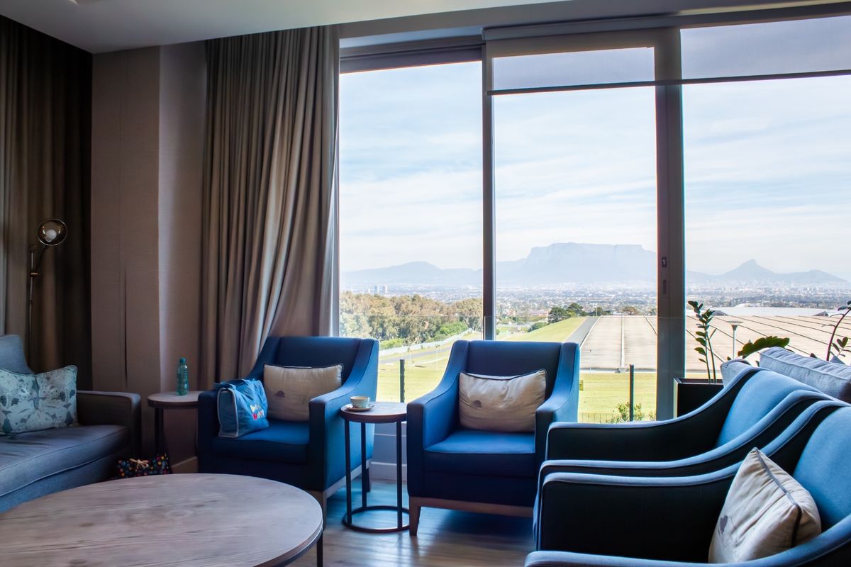 A comfortable living area featuring floor-to-ceiling windows that offer expansive views of the surrounding landscape and mountains.