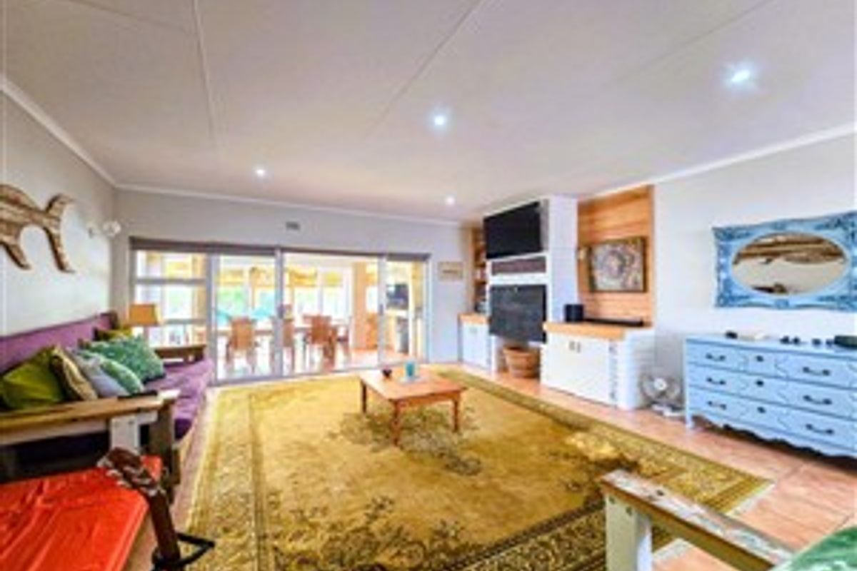 Spacious living room featuring tiled flooring, recessed downlights, and large sliding glass doors that provide access to the outdoor patio area.