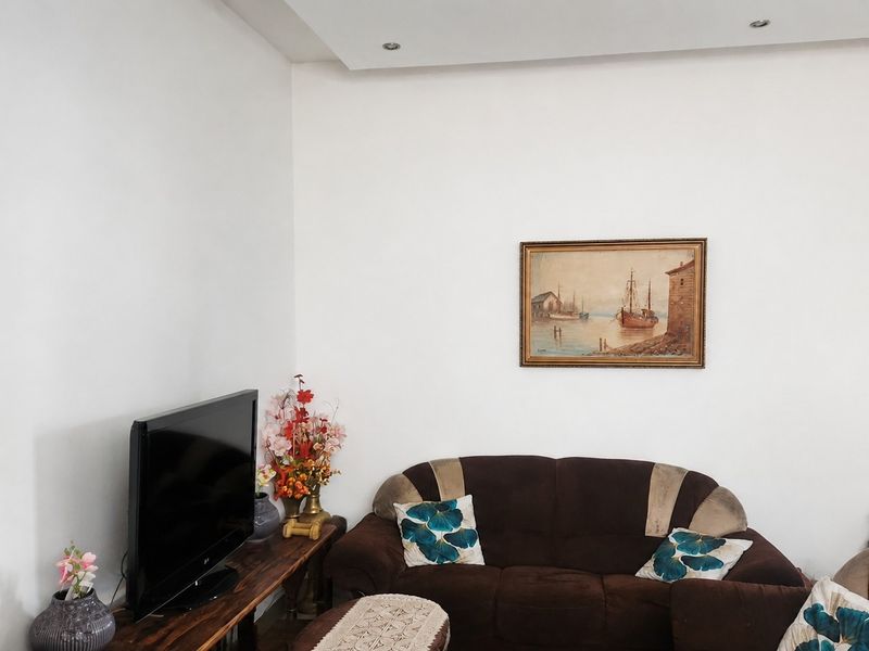 A living room area featuring recessed ceiling lighting and neutral wall finishes, providing a functional space for relaxation.