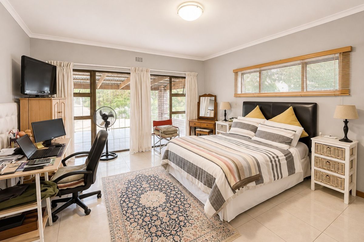 Spacious bedroom featuring tiled flooring, large sliding glass doors providing natural light, and neutral wall finishes.