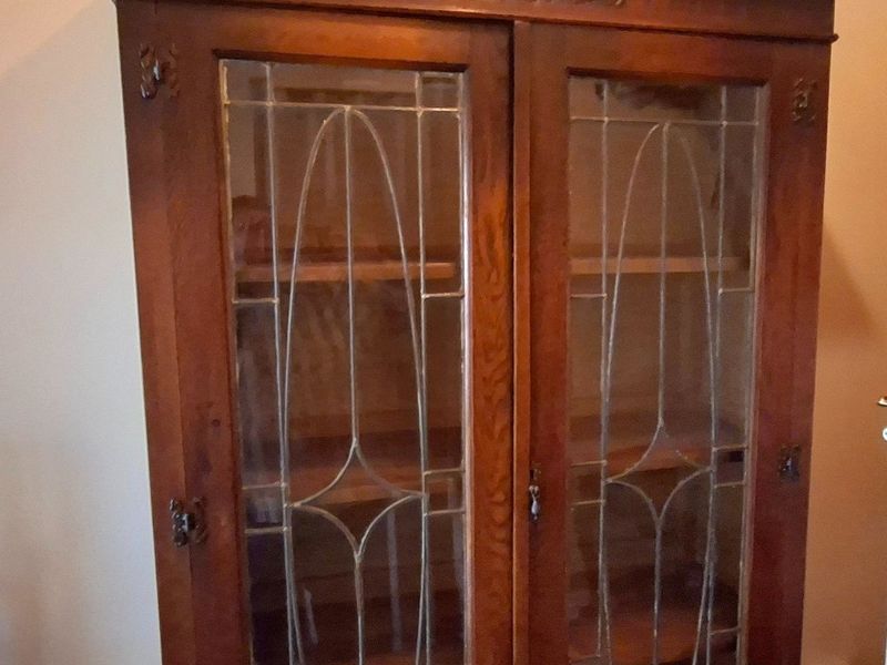 A close-up view of a wooden cabinet with glass doors, which is a movable piece of furniture and not a fixed property asset.