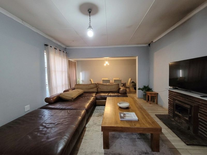 Open-plan living and dining area featuring a built-in fireplace, tiled flooring, and neutral wall tones, providing a functional and connected living space.