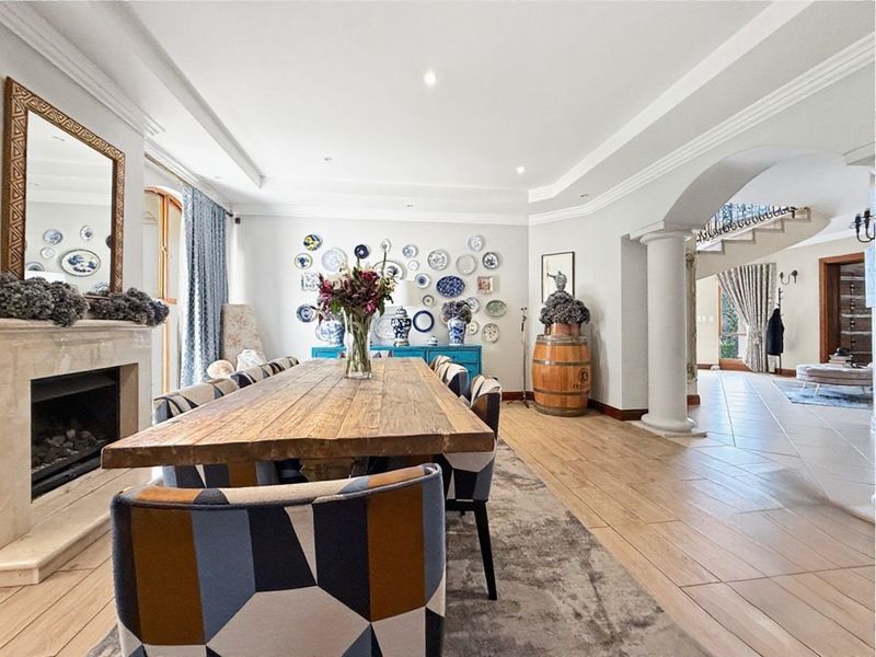 Spacious dining room featuring a fireplace, elegant crown molding, recessed lighting, and an open-plan layout with a decorative archway leading to the entrance hall.