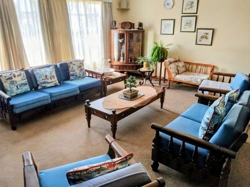 A spacious living room featuring carpeted flooring and large windows that provide ample natural light.
