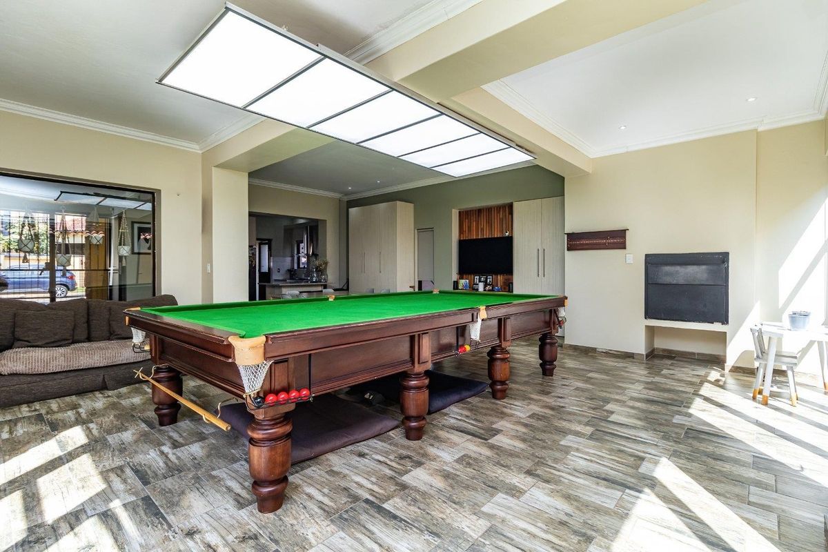Spacious living area featuring tiled flooring, built-in cabinetry, a fireplace, and a large overhead light fixture, with direct access to the exterior.