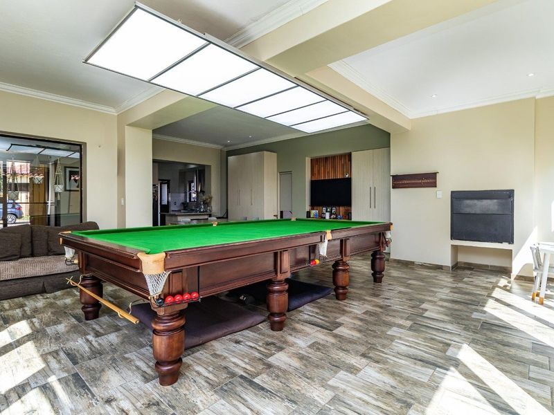 Spacious living area featuring tiled flooring, built-in cabinetry, a fireplace, and a large overhead light fixture, with direct access to the exterior.