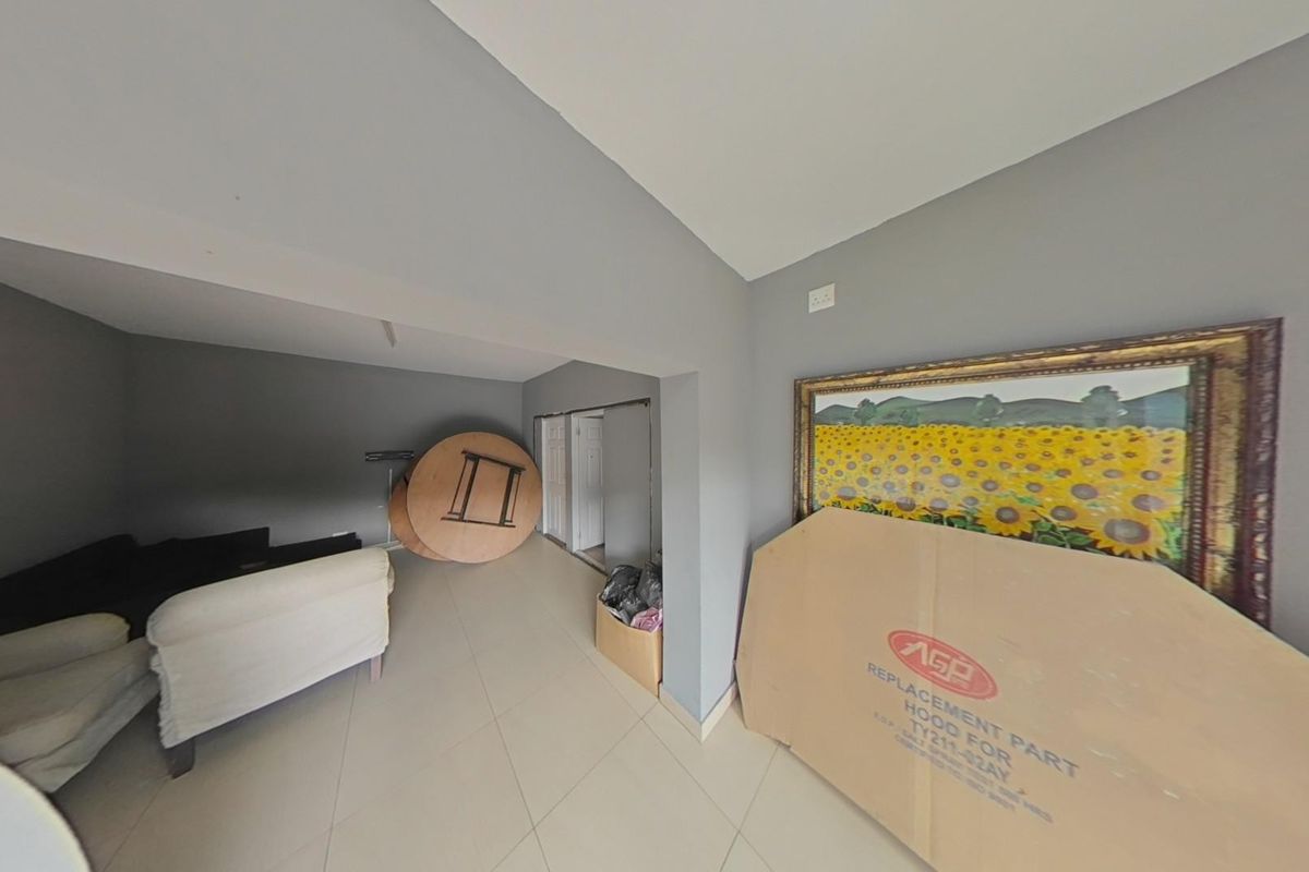 A living area featuring neutral grey walls and tiled flooring, offering a versatile space for interior design and layout customization.