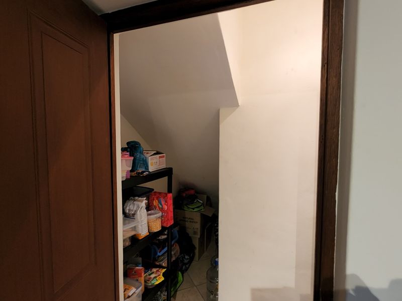 A functional under-stair storage cupboard providing convenient additional utility space within the home.