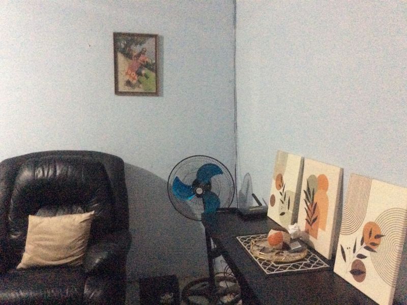 A small living area featuring light blue walls and basic interior finishes, suitable for potential renovation or restyling to enhance the space.