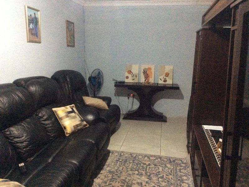 A living room area featuring tiled flooring and decorative coving, providing a functional space for relaxation.