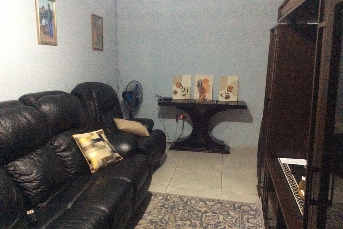 A living room area featuring tiled flooring and decorative coving, providing a functional space for relaxation.
