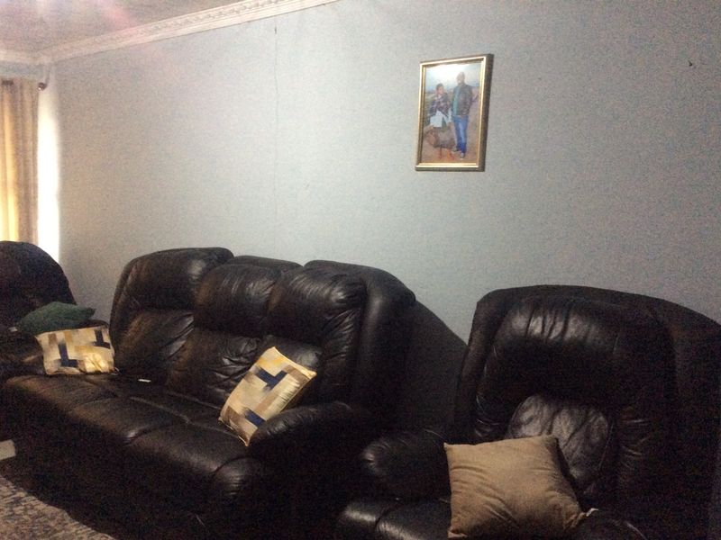 A living room space featuring decorative ceiling cornicing and a visible vertical crack on the wall surface.