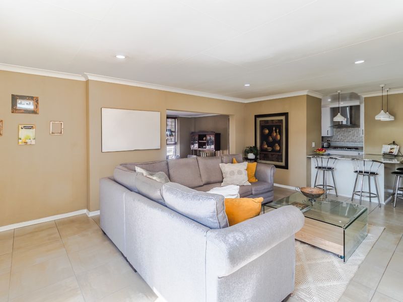 Open plan living area featuring tiled flooring, recessed lighting, and a kitchen with a breakfast bar and integrated extractor fan.