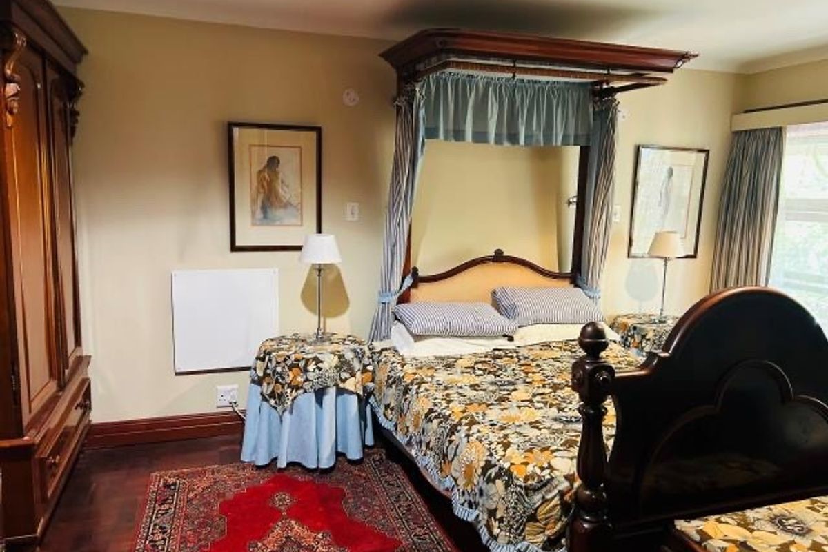 A traditional bedroom featuring dark hardwood flooring and a built-in wardrobe, offering a classic aesthetic with potential for modern updates.