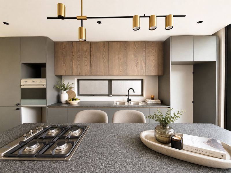 Modern kitchen featuring a central island with integrated gas cooktop, sleek cabinetry, built-in oven, and high-quality finishes throughout.