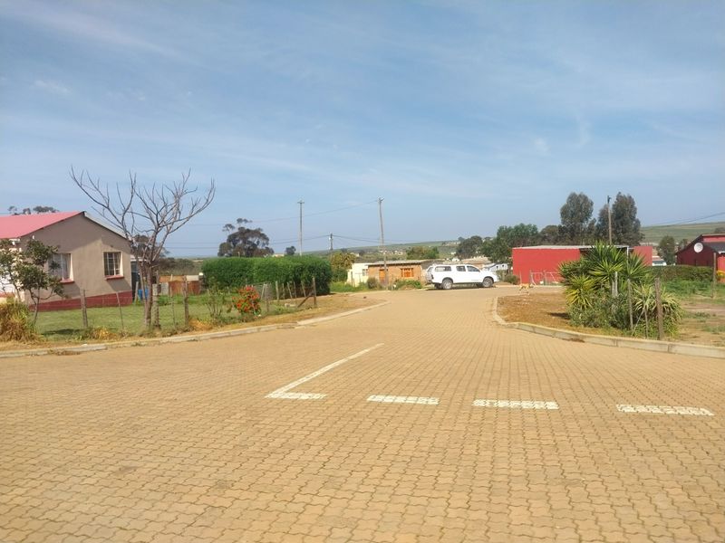 A view of a paved residential street with surrounding properties and utility infrastructure in a suburban setting.