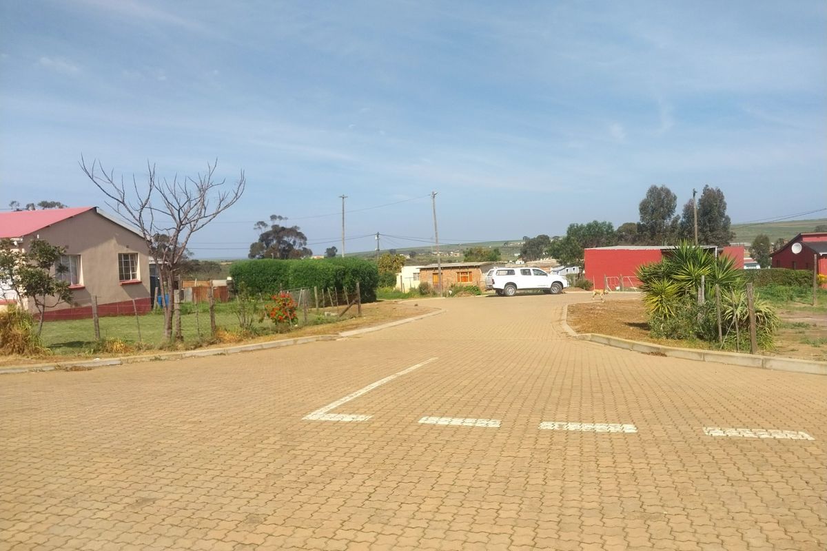 A view of a paved residential street with surrounding properties and utility infrastructure in a suburban setting.