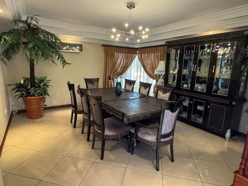 A formal dining room featuring tiled flooring, decorative cove ceiling, and modern lighting fixtures, creating a sophisticated space for entertaining.