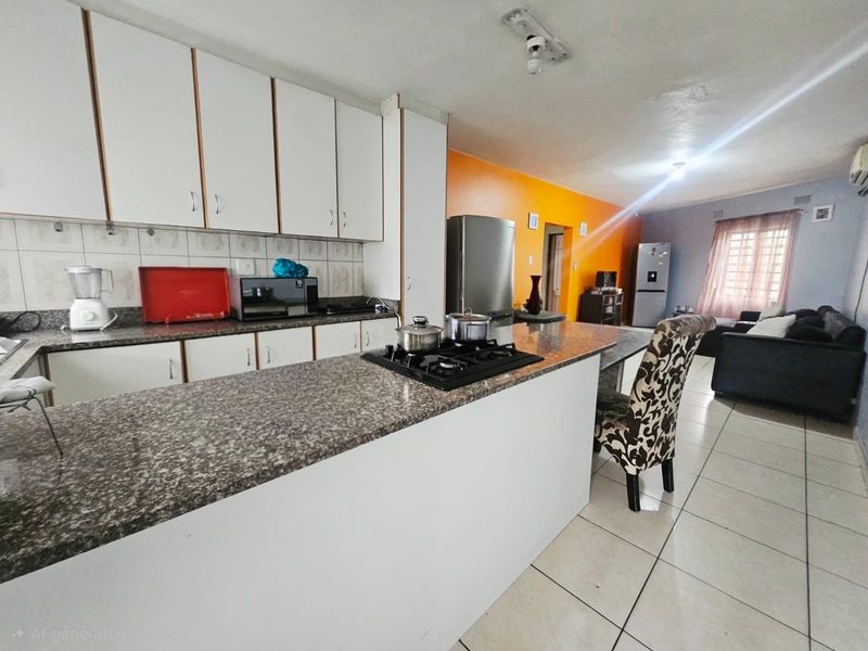Open-plan kitchen and living area featuring granite countertops, built-in cabinetry, and tiled flooring, offering a functional layout for modern living.
