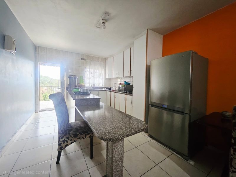 A functional kitchen featuring built-in cabinetry, granite countertops with an integrated breakfast bar, and tiled flooring, with direct access to an outdoor area.