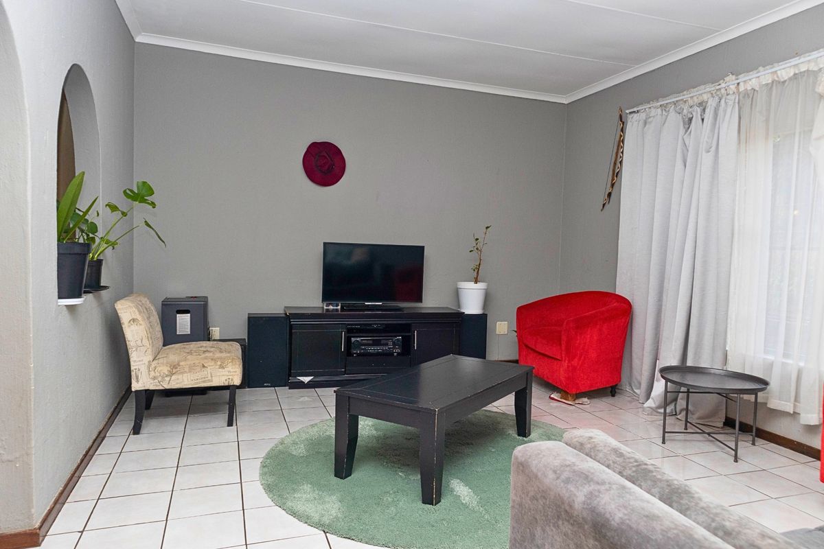 A living room featuring tiled flooring, a coved ceiling, and a decorative arched wall niche.