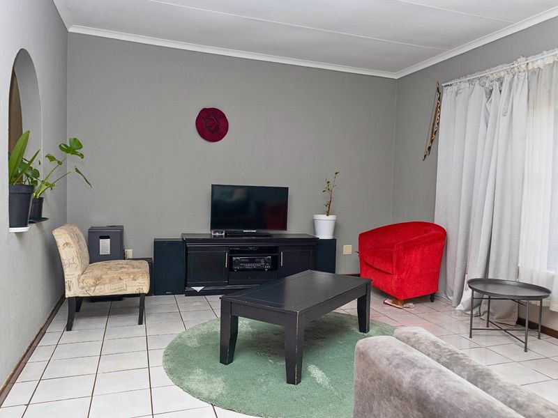 A living room featuring tiled flooring, a coved ceiling, and a decorative arched wall niche.