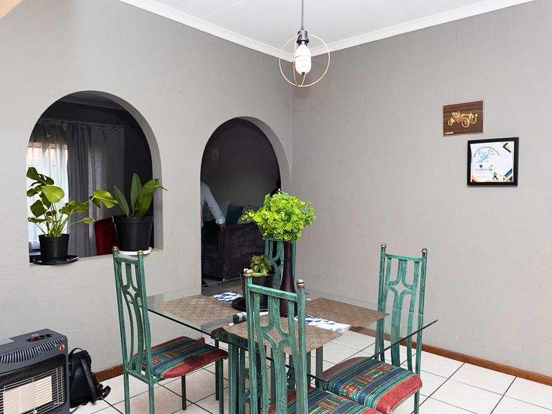 Dining area featuring tiled flooring and distinctive arched wall openings connecting to adjacent living spaces.