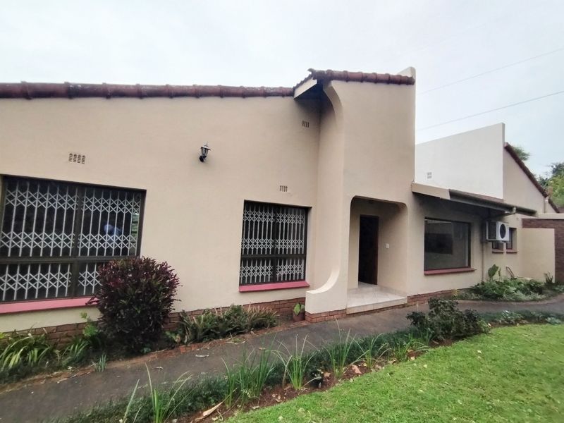 Front facade of a single-story house featuring security gates, a paved walkway, and an external air conditioning unit.