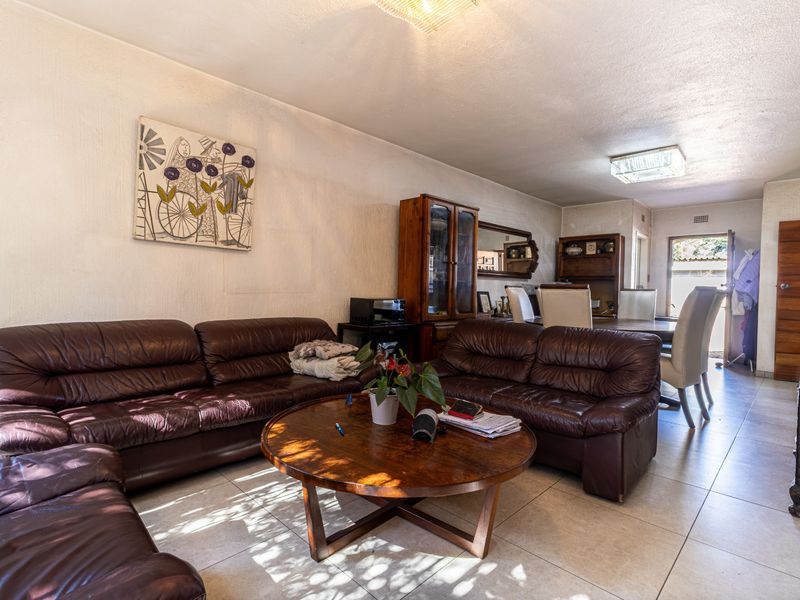 Open plan living and dining area featuring neutral tiled flooring and direct access to the exterior.