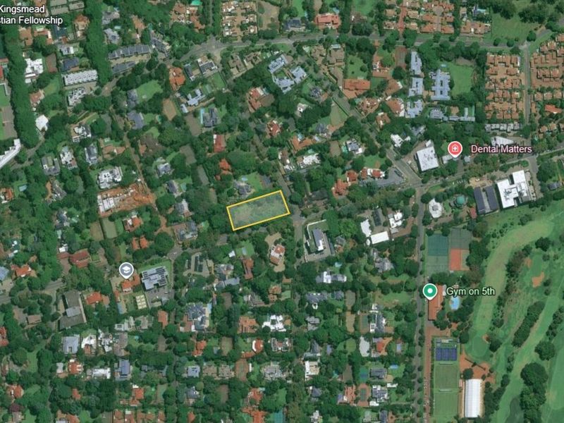 Aerial view of a vacant land parcel located in a well-established commercial and residential area.