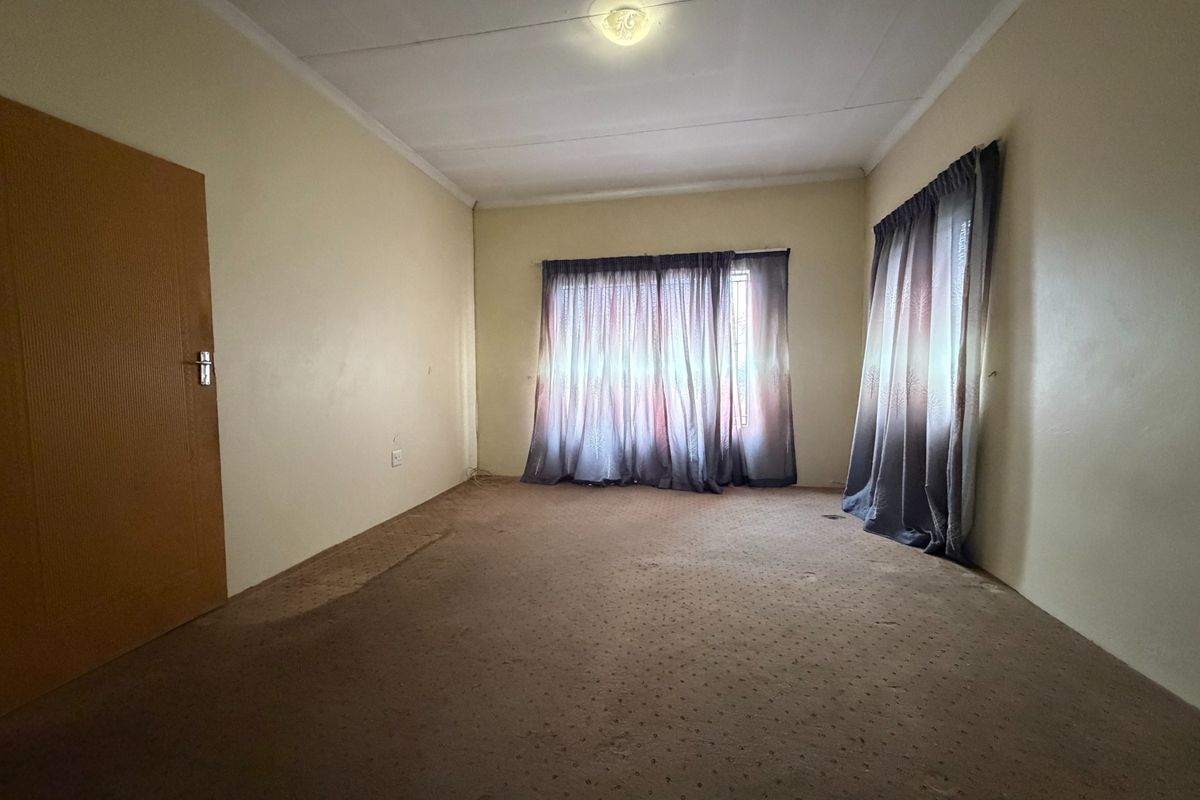 A vacant bedroom featuring carpeted flooring and neutral walls, offering a blank canvas for potential updates and interior design improvements.