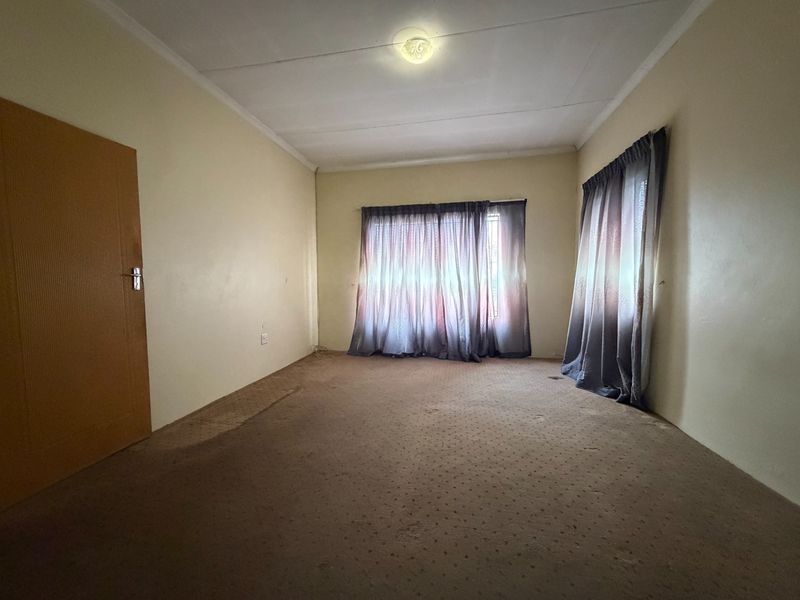 A vacant bedroom featuring carpeted flooring and neutral walls, offering a blank canvas for potential updates and interior design improvements.