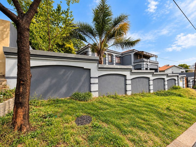 A view of the property's front boundary wall and landscaped verge, showcasing the exterior facade and perimeter security wall.