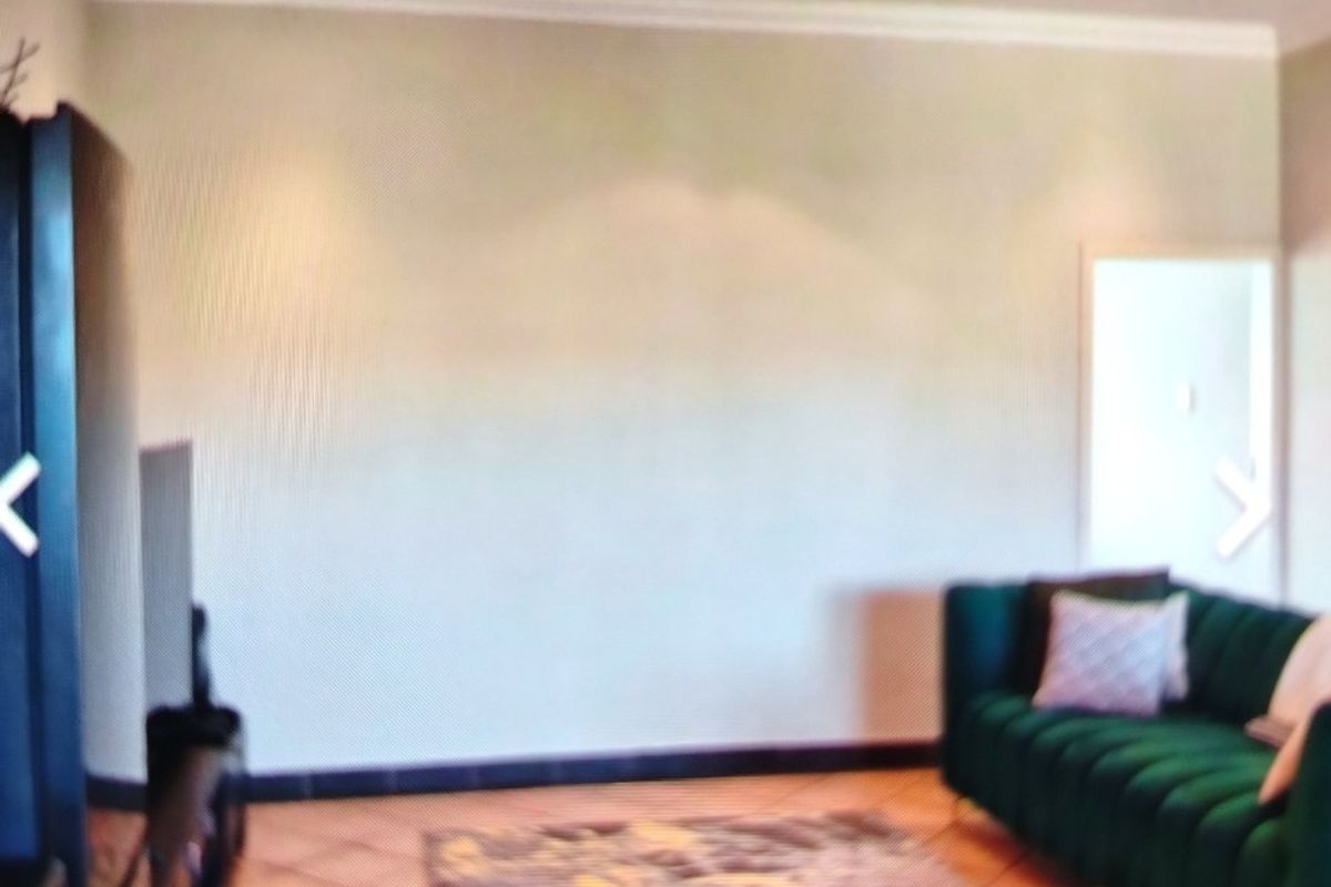 A living room featuring tiled flooring, recessed downlighting, and coved ceiling details, providing a neutral base for interior design.