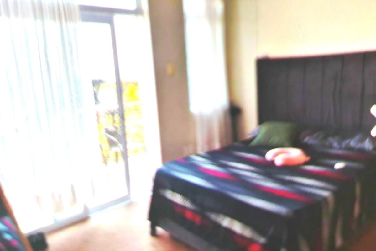A bedroom featuring a sliding glass door providing natural light and access to an outdoor area.